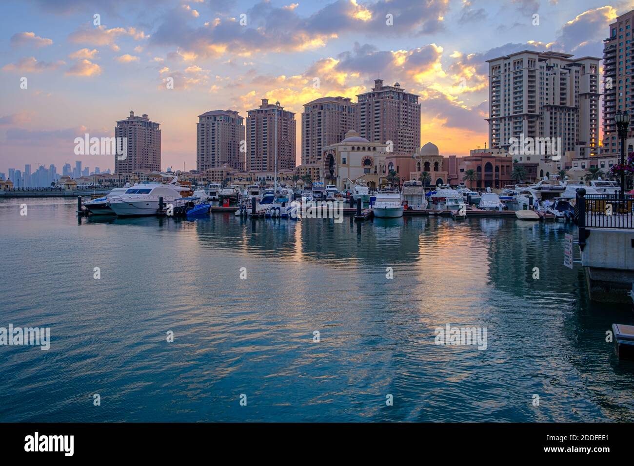 La perla Marina di Doha Qatar vista diurna con yacht in primo piano, edifici e nuvole nel cielo in background Foto Stock