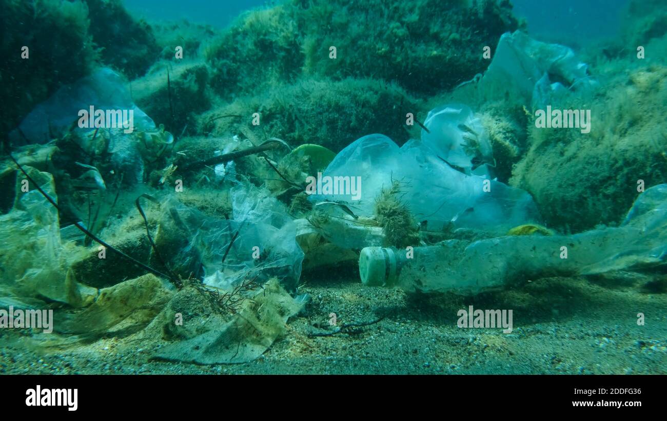 Primo piano del fondo marino coperto con un sacco di rifiuti di plastica. Bottiglie, borse e altri detriti di plastica sul fondo marino dell'Adriatico. Inquinamento plastico di t Foto Stock