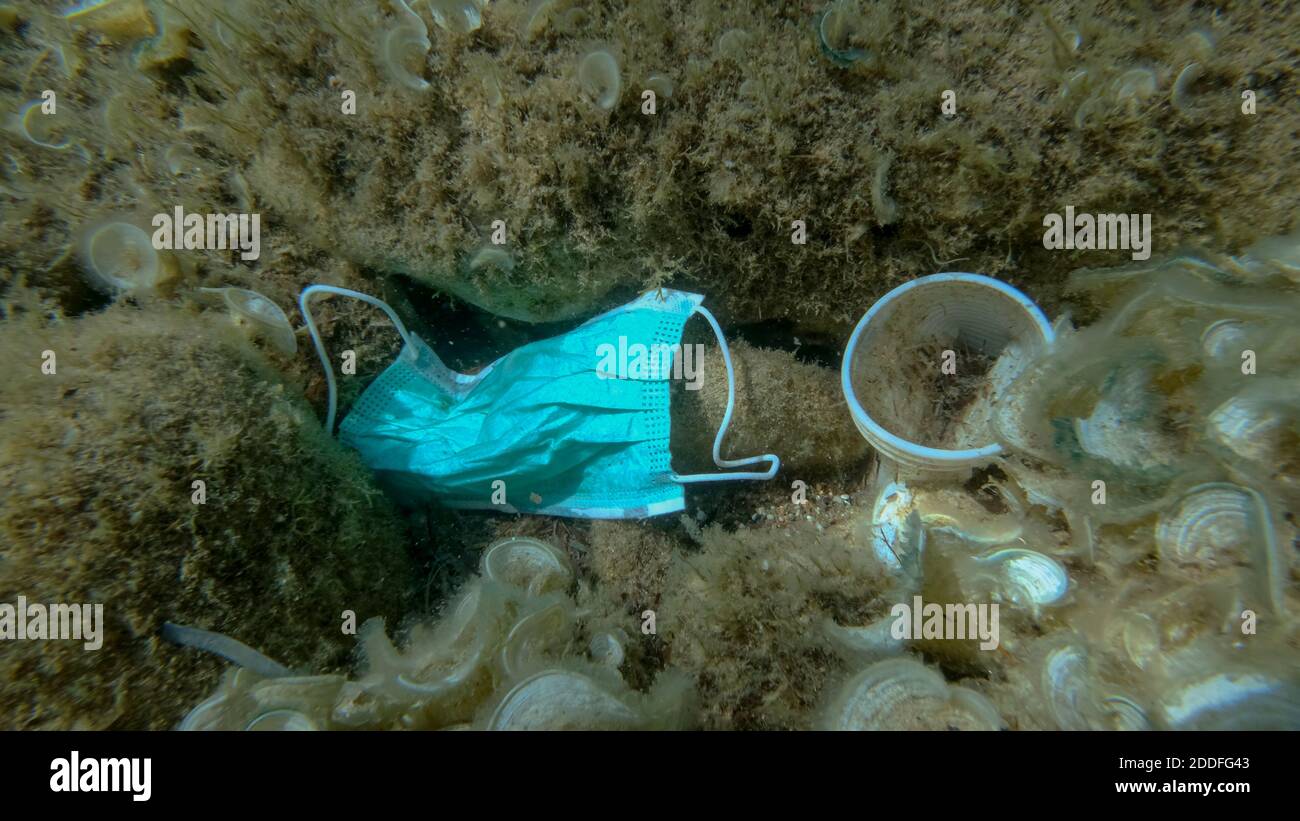 Inquinamento da plastica - bottiglie, sacchetti e altri detriti di plastica sul fondo marino. Il coronavirus COVID-19 contribuisce all'inquinamento, poiché le maschere usate scartate si ingarocchiano Foto Stock