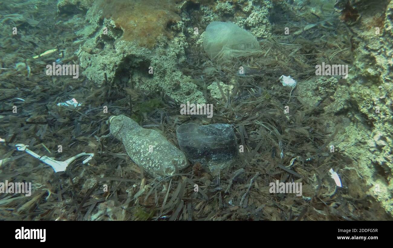 Massiccio inquinamento plastico del fondo oceanico. Fondo marino coperto con un sacco di rifiuti di plastica. Bottiglie, sacchetti e altri detriti di plastica sul fondo marino di Medit Foto Stock