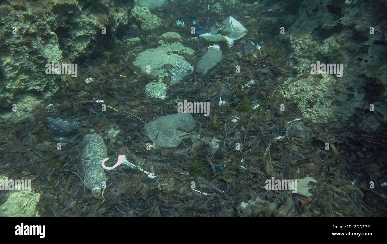 Massiccio inquinamento plastico del fondo oceanico. Fondo marino coperto con un sacco di rifiuti di plastica. Bottiglie, sacchetti e altri detriti di plastica sul fondo marino di Medit Foto Stock