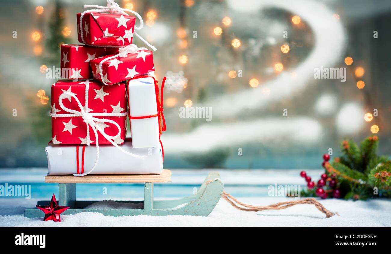 Regali di Natale su slitte di legno con sfondo festivo Foto Stock