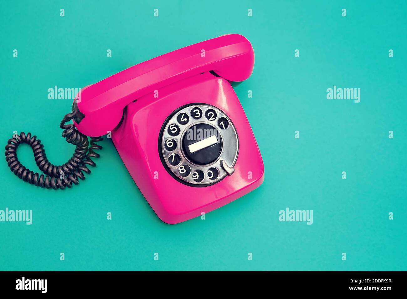 Telefono in plastica vintage su sfondo ciano. Foto Stock