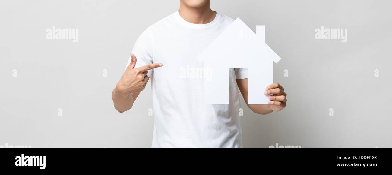 Immagine banner panoramica di un uomo anonimo che tiene e punta a. casa gabbie su isolato sfondo grigio chiaro Foto Stock