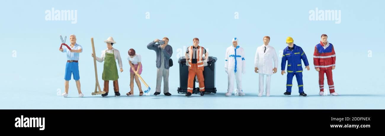 Un closeup di persone giocattolo con diversi lavori su un sfondo blu Foto Stock