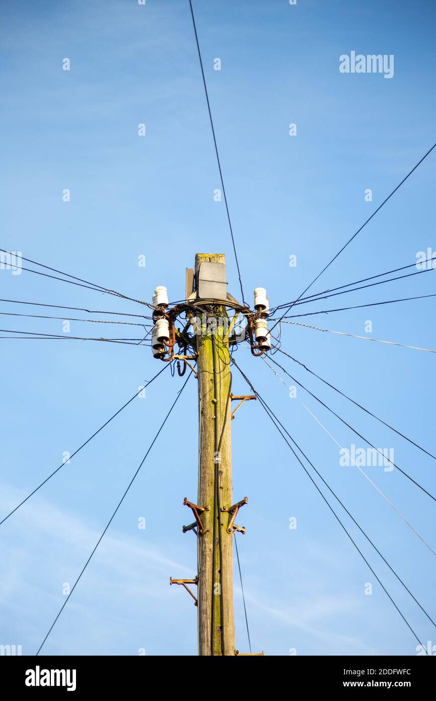 Una linea telefonica pilone in una strada inglese Foto Stock