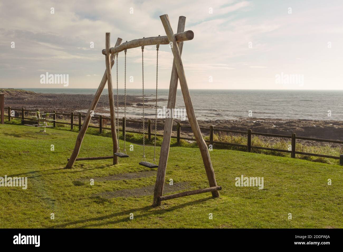 Due altalene per bambini in un parco sul mare, a Caal, Fife, Scozia. Le altalene sono vuote, pronte per i prossimi due bambini a divertirsi. Foto Stock