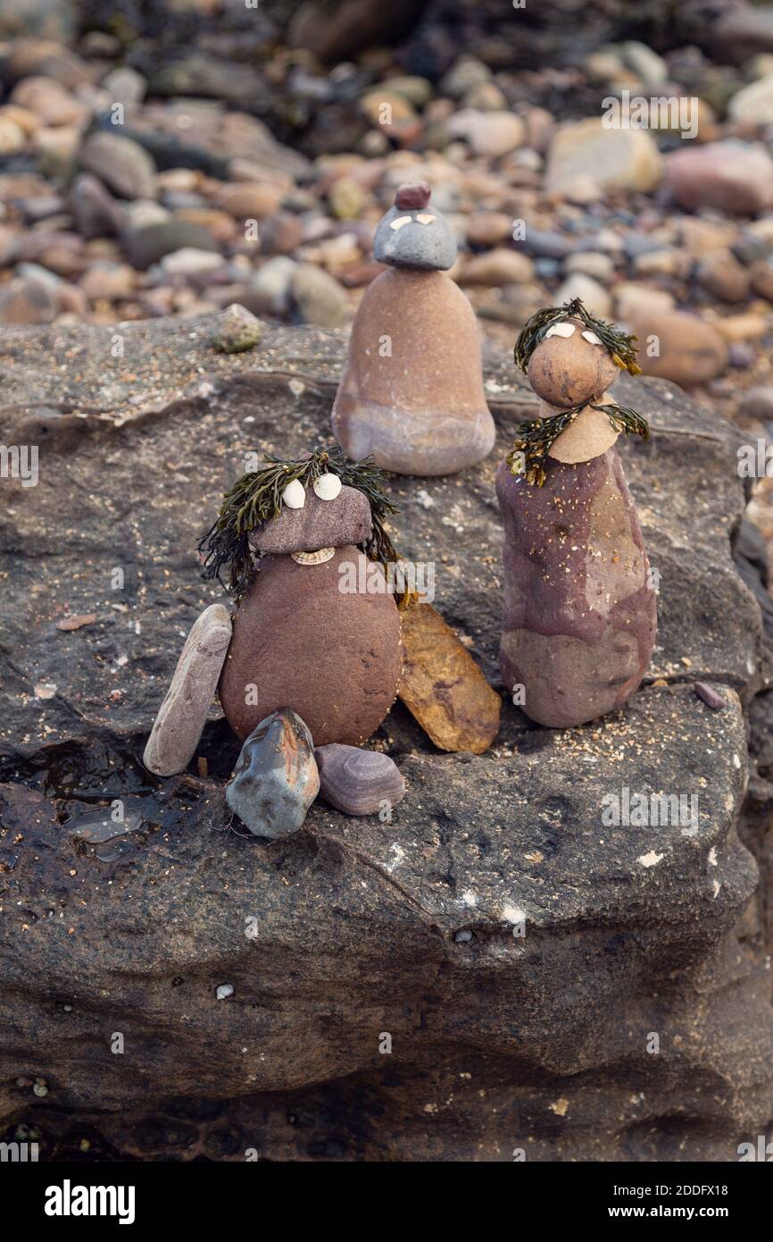 Piccole statuette di roccia realizzate dai bambini in una giornata in spiaggia. I bambini amano fare questo tipo di attività. Foto Stock