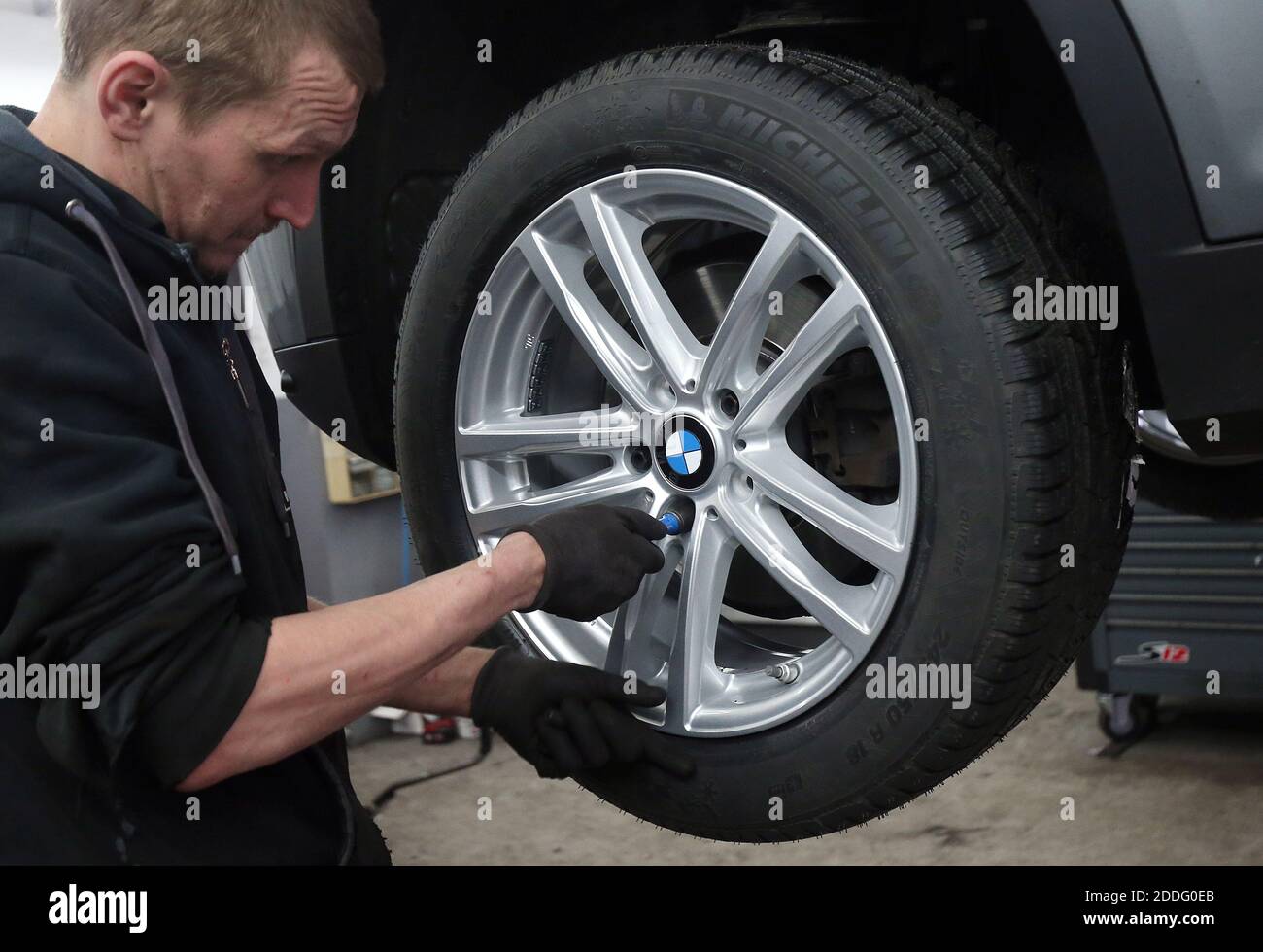 Berlino, Germania. 25 Nov 2020. Un meccanico presso un'officina di riparazione auto nel distretto di Lichtenberg cambia un veicolo da pneumatici estivi a pneumatici invernali. La regola generale per un cambio stagionale di pneumatico è: Da A a o (giorno di tutti i Santi a Pasqua). Chiunque abbia un incidente con gli pneumatici estivi nonostante le cattive condizioni atmosferiche pagherà una multa pesante (requisito degli pneumatici invernali). Gli pneumatici invernali sono più efficaci quando la temperatura media è inferiore a sette gradi Celsius. Credit: Wolfgang Kumm/dpa/Alamy Live News Foto Stock
