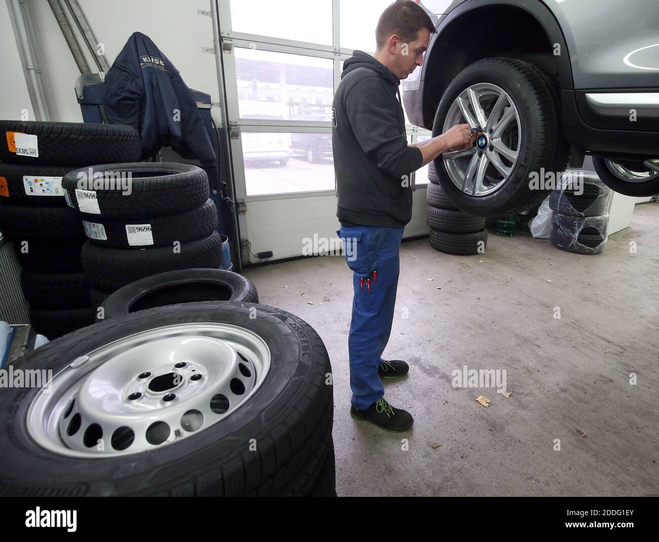 Berlino, Germania. 25 Nov 2020. Un meccanico presso un'officina di riparazione auto nel distretto di Lichtenberg cambia un veicolo da pneumatici estivi a pneumatici invernali. La regola generale per un cambio stagionale di pneumatico è: Da A a o (giorno di tutti i Santi a Pasqua). Chiunque abbia un incidente con gli pneumatici estivi nonostante le cattive condizioni atmosferiche pagherà una multa pesante (requisito degli pneumatici invernali). Gli pneumatici invernali sono più efficaci quando la temperatura media è inferiore a sette gradi Celsius. Credit: Wolfgang Kumm/dpa/Alamy Live News Foto Stock