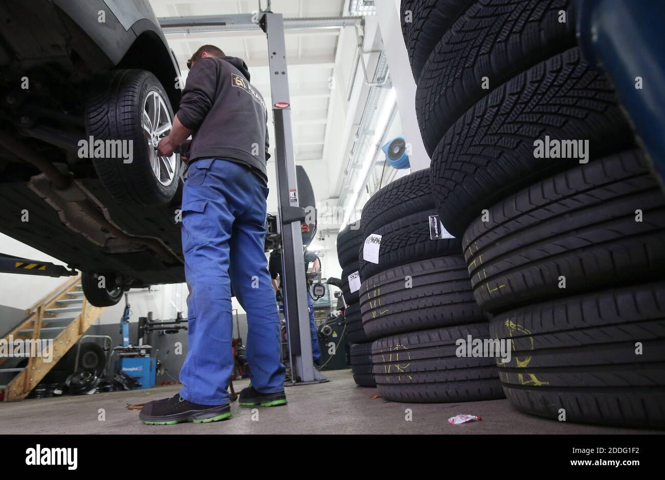 Berlino, Germania. 25 Nov 2020. Un meccanico presso un'officina di riparazione auto nel distretto di Lichtenberg cambia un veicolo da pneumatici estivi a pneumatici invernali. La regola generale per un cambio stagionale di pneumatico è: Da A a o (giorno di tutti i Santi a Pasqua). Chiunque abbia un incidente con gli pneumatici estivi nonostante le cattive condizioni atmosferiche pagherà una multa pesante (requisito degli pneumatici invernali). Gli pneumatici invernali sono più efficaci quando la temperatura media è inferiore a sette gradi Celsius. Credit: Wolfgang Kumm/dpa/Alamy Live News Foto Stock
