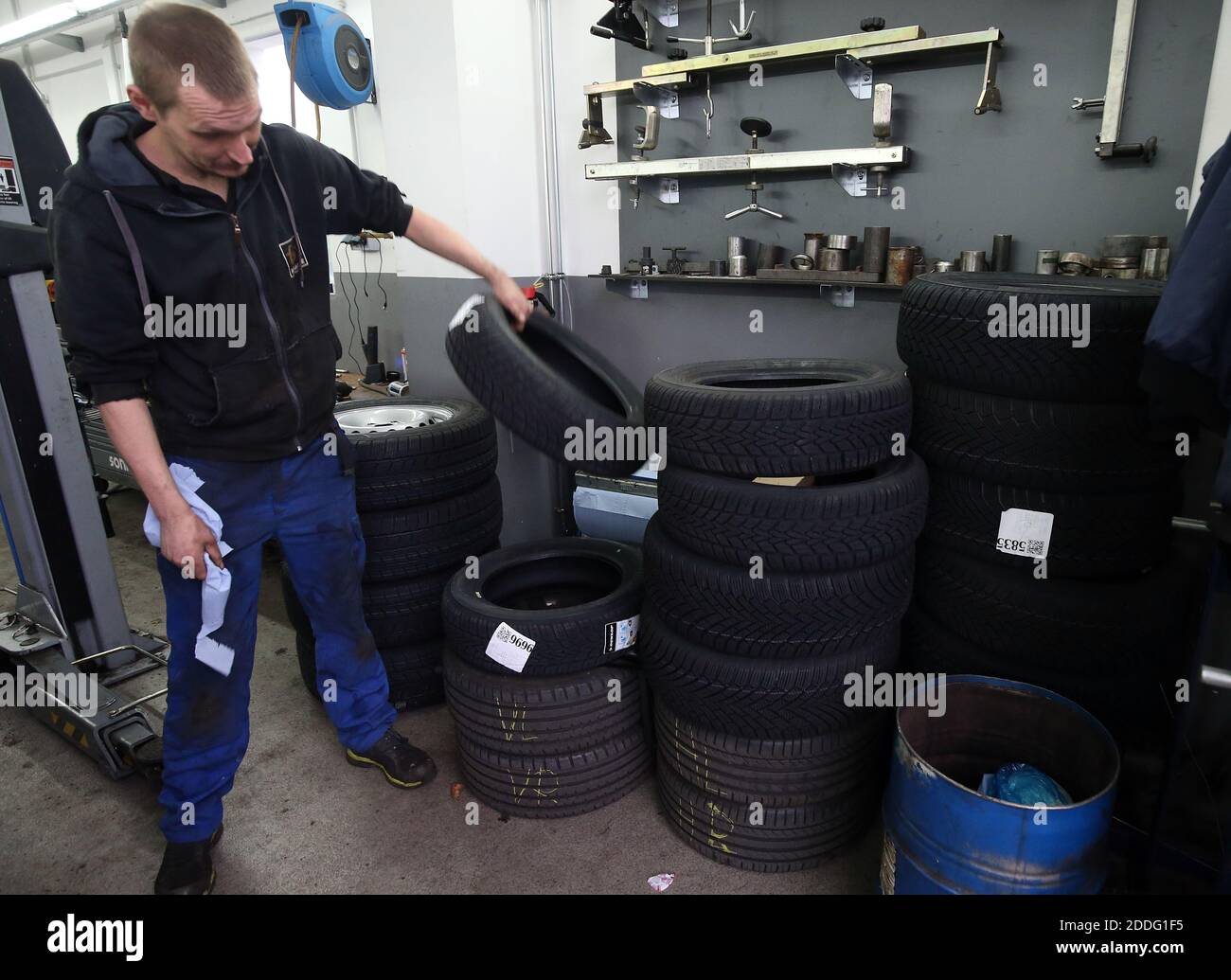 Berlino, Germania. 25 Nov 2020. Un meccanico presso un'officina di riparazione auto nel distretto di Lichtenberg impila gli pneumatici per passare da pneumatici estivi a pneumatici invernali. La regola generale per un cambio stagionale di pneumatico è: Da A a o (giorno di tutti i Santi a Pasqua). Chiunque abbia un incidente con gli pneumatici estivi nonostante le cattive condizioni atmosferiche pagherà una multa pesante (obbligo di pneumatici invernali). Gli pneumatici invernali sono più efficaci quando la temperatura media è inferiore a sette gradi Celsius. Credit: Wolfgang Kumm/dpa/Alamy Live News Foto Stock