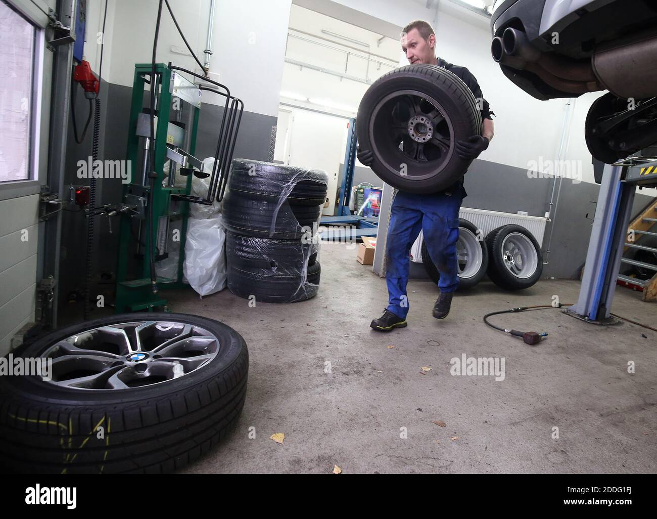 Berlino, Germania. 25 Nov 2020. Un meccanico presso un'officina di riparazione auto nel distretto di Lichtenberg cambia un veicolo da pneumatici estivi a pneumatici invernali. La regola generale per un cambio stagionale di pneumatico è: Da A a o (giorno di tutti i Santi a Pasqua). Chiunque abbia un incidente con gli pneumatici estivi nonostante le cattive condizioni atmosferiche pagherà una multa pesante (requisito degli pneumatici invernali). Gli pneumatici invernali sono più efficaci quando la temperatura media è inferiore a sette gradi Celsius. Credit: Wolfgang Kumm/dpa/Alamy Live News Foto Stock