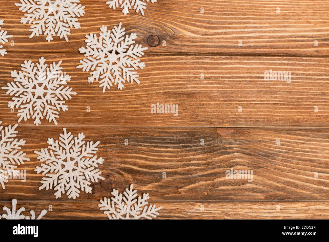 vista dall'alto dei fiocchi di neve invernali su sfondo di legno Foto Stock