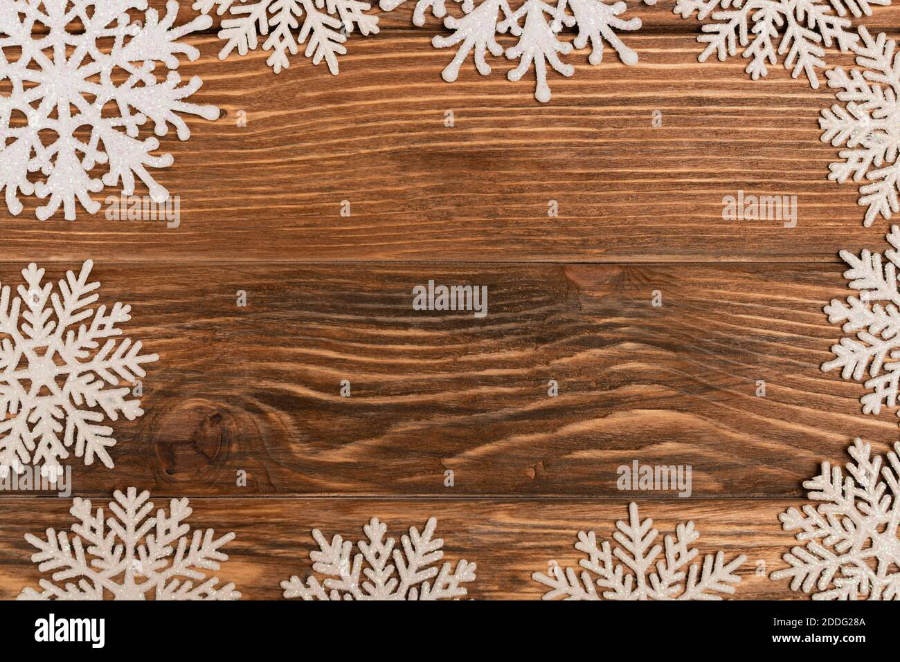 vista dall'alto dei fiocchi di neve invernali su sfondo di legno Foto Stock