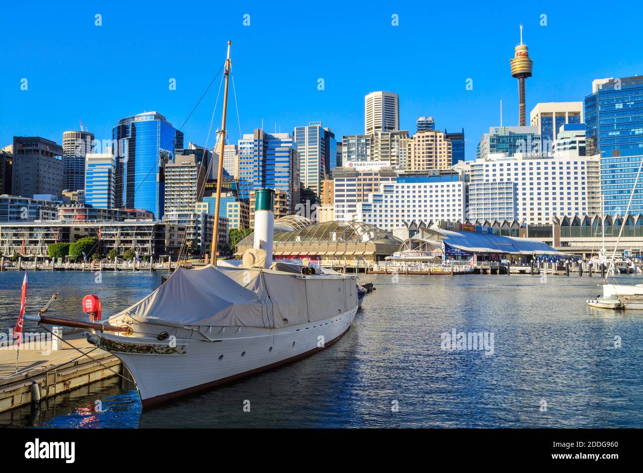 Darling Harbour, Sydney, Australia. Lo storico yacht a vapore 'Ena' (costruito nel 1900) galleggia in acqua con lo skyline di Sydney alle spalle Foto Stock