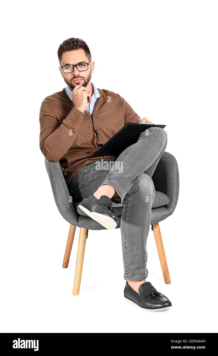 Psicologo maschile seduto in poltrona su sfondo bianco Foto stock - Alamy
