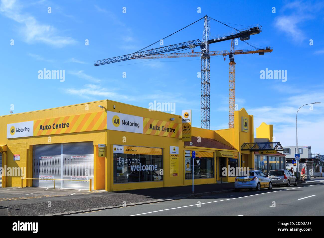 L'edificio AA (Automobile Association) a Tauranga, Nuova Zelanda, con due gru da costruzione in funzione sullo sfondo Foto Stock