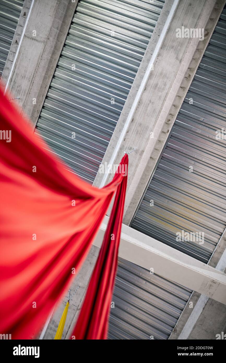 da sotto pezzo di stoffa rossa appeso al soffitto in metallo in studio di danza aerea Foto Stock