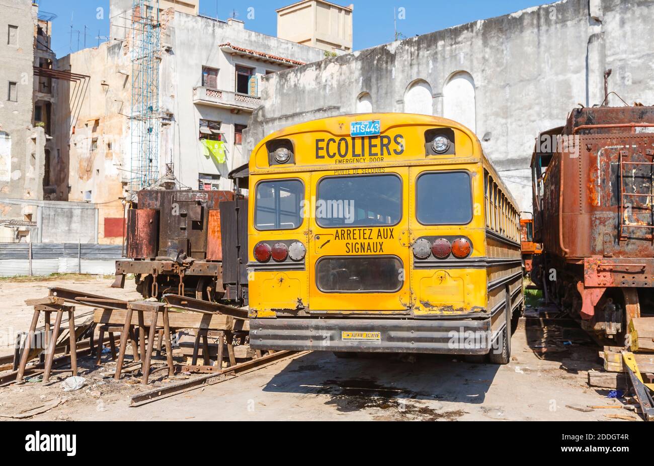 Un tipico autobus scolastico giallo vintage Blue Bird parcheggiato in un cantiere ferroviario nel centro di Old Havana, capitale di Cuba Foto Stock