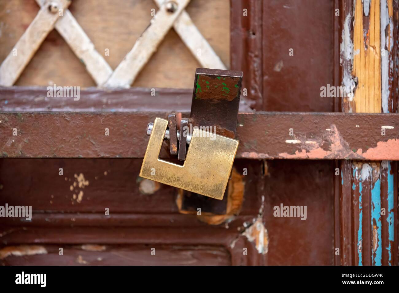 Lucchetto in metallo pesante con chiusura a catena su un cancello d'ingresso di colore marrone. Concetto di sicurezza Foto Stock