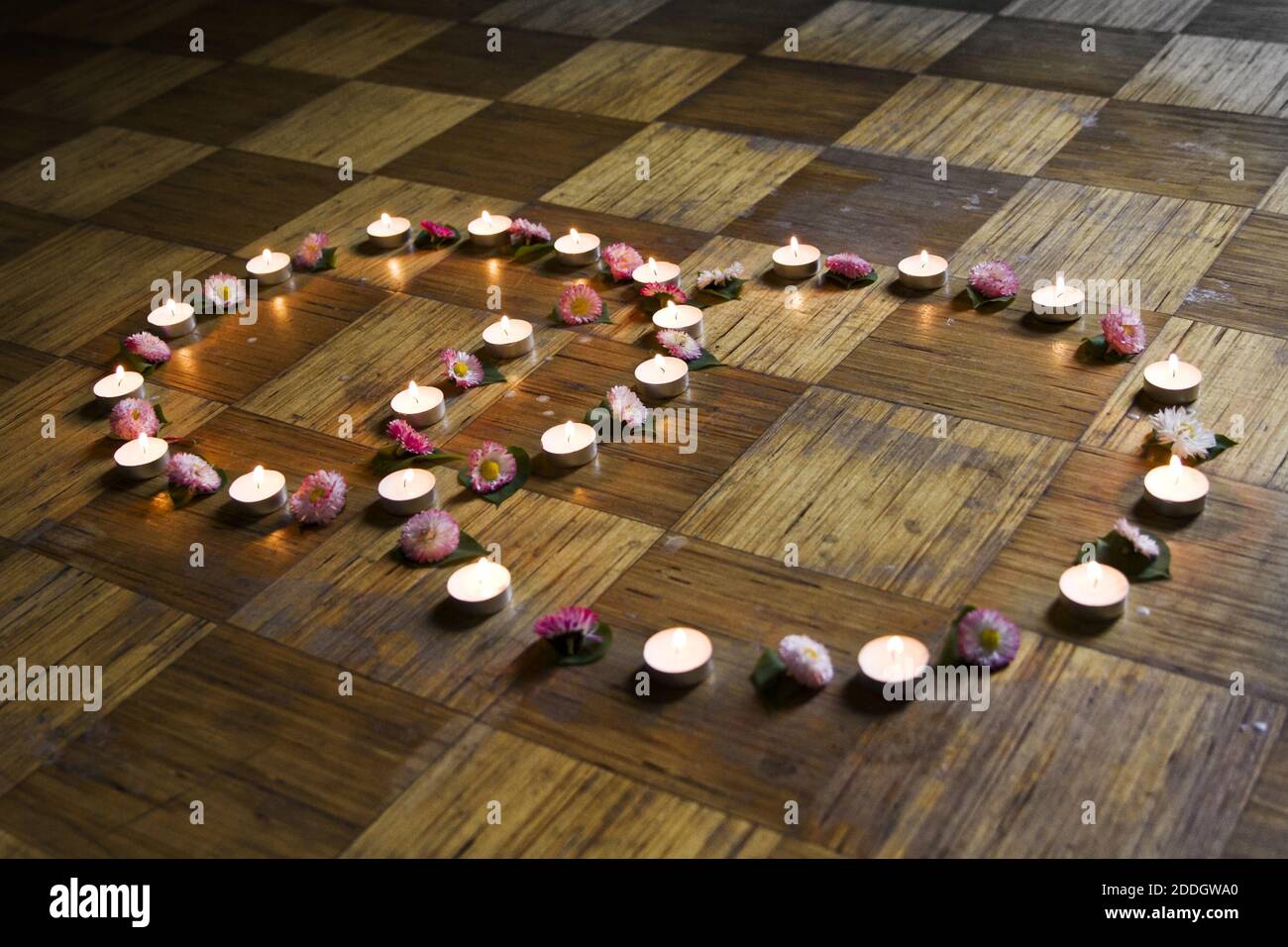 Candele illuminate e decorazioni floreali sul pavimento Foto Stock