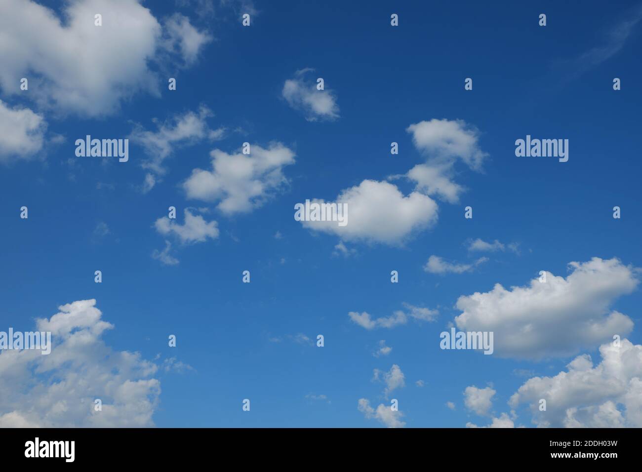 Piccole nuvole di cumulo su un cielo blu. Sfondo. Foto Stock