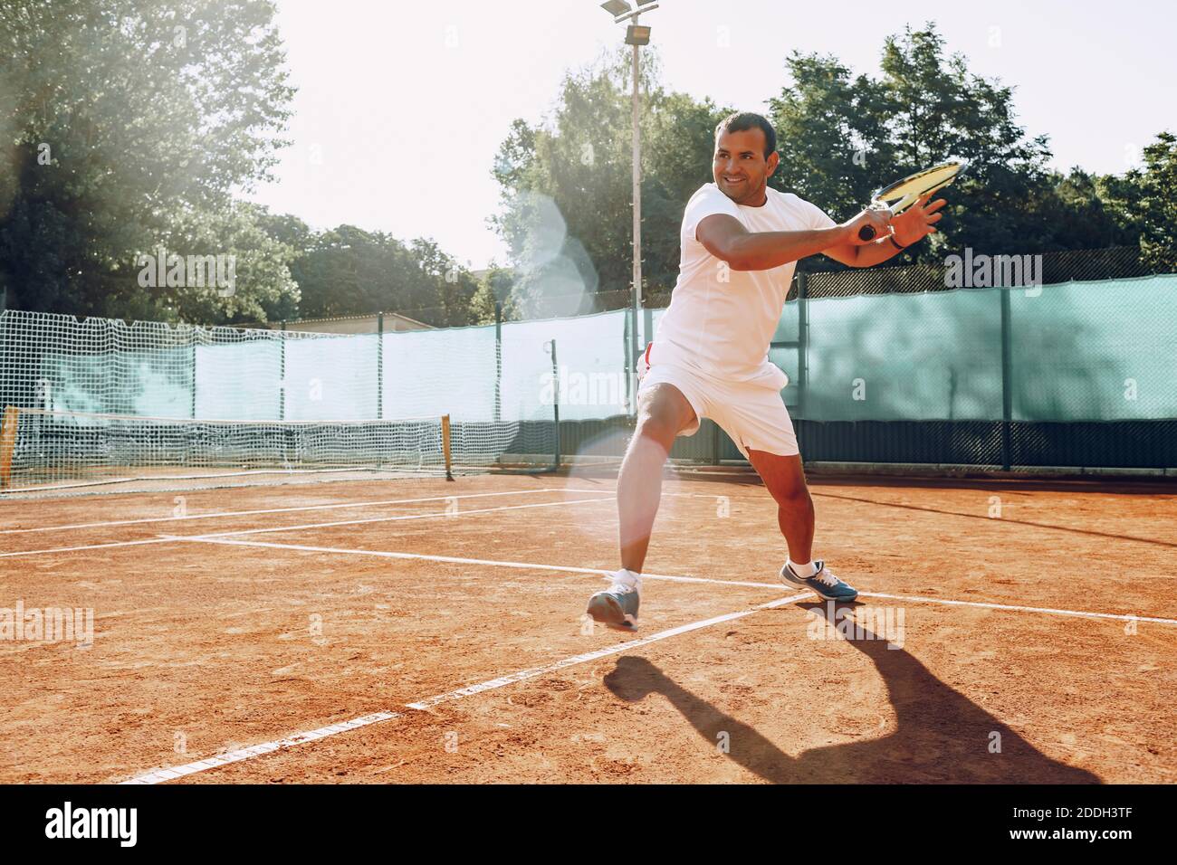 Fit Man gioca a tennis su campo Foto Stock