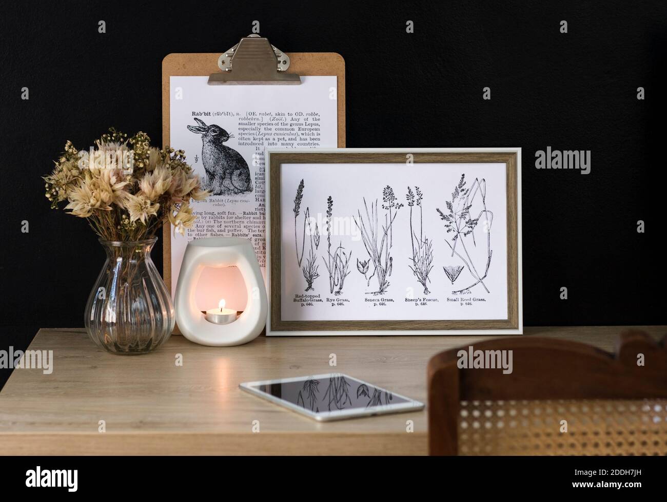 Una tranquilla scrivania da home Office con elementi decorativi naturali. Lo spazio è ordinato e favorisce la produttività in un ambiente calmante. Foto Stock