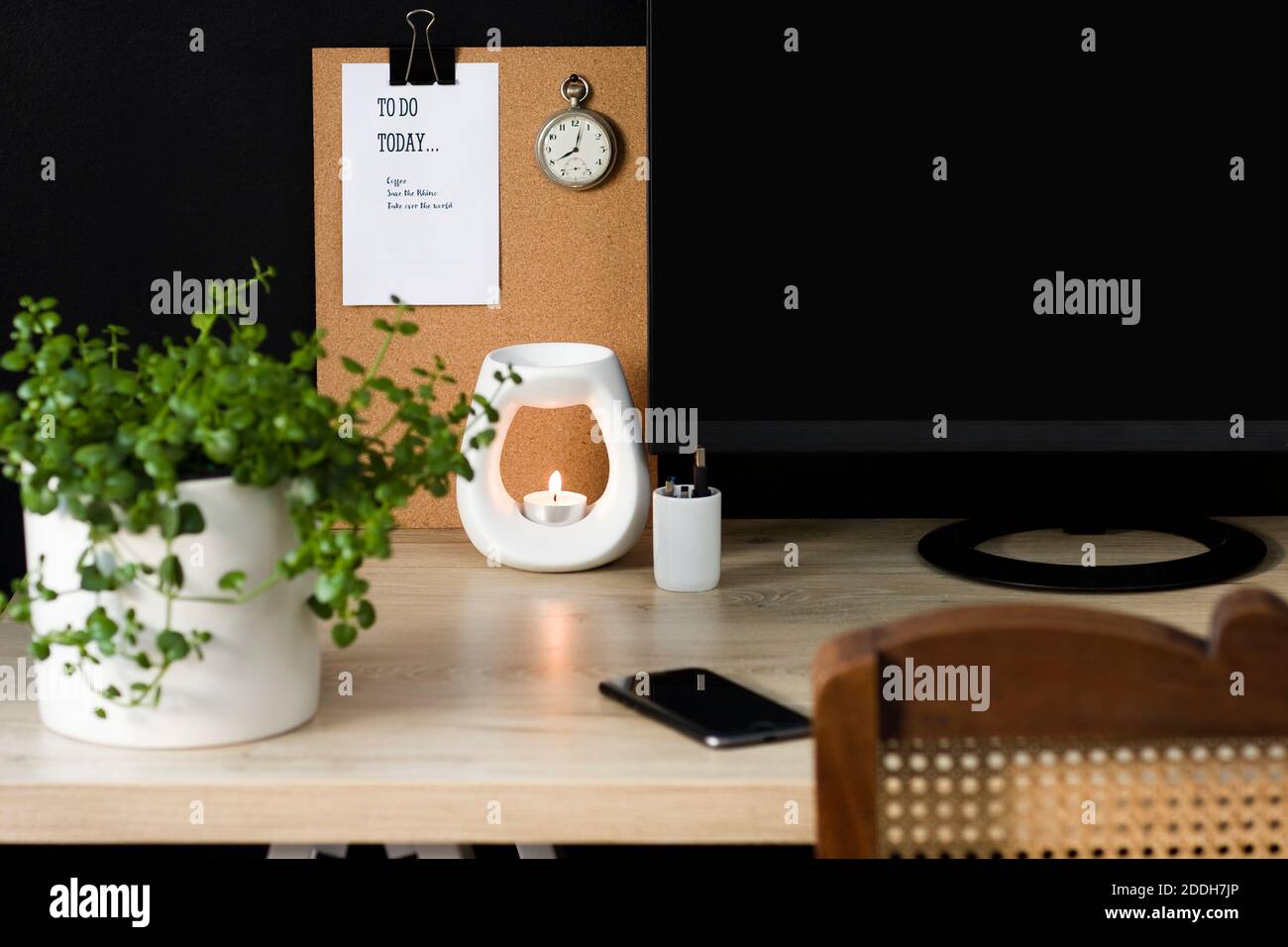 Una tranquilla scrivania da home Office con elementi decorativi naturali. Lo spazio è ordinato e favorisce la produttività in un ambiente calmante. Foto Stock