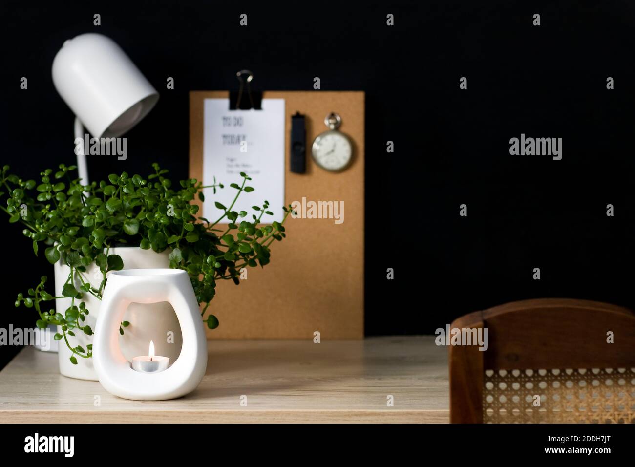 Una tranquilla scrivania da home Office con elementi decorativi naturali. Lo spazio è ordinato e favorisce la produttività in un ambiente calmante. Foto Stock