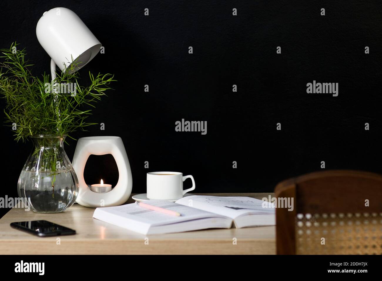 Una tranquilla scrivania da home Office con elementi decorativi naturali. Lo spazio è ordinato e favorisce la produttività in un ambiente calmante. Foto Stock