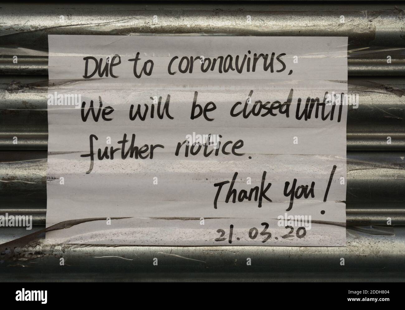 Un segno scritto a mano da marzo, fotografato alla fine di novembre, che significa che un'azienda è chiusa a causa di Coronavirus. Foto Stock