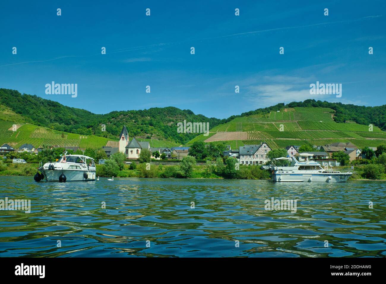 Due barche a motore sul fiume Reno in Germania con alcuni edifici e verdi colline sullo sfondo Foto Stock