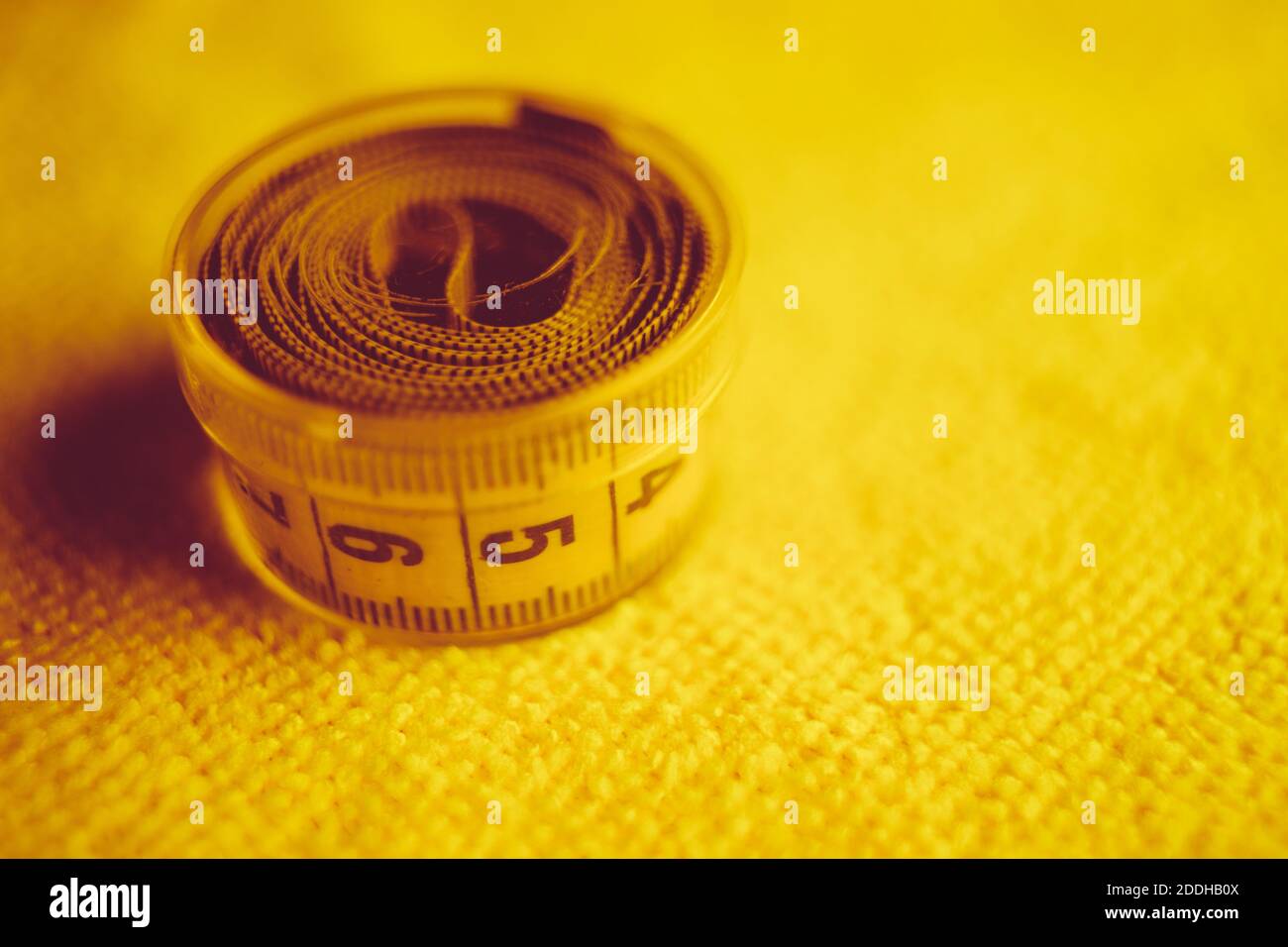 Nastro di misurazione giallo in scatola chiusa sulla tavola degli asciugamani Foto Stock