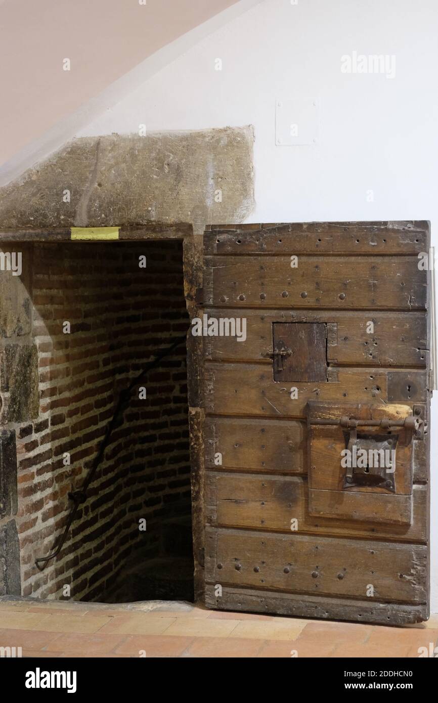 Antica porta in legno con spioncino ruvida con le scale per il tetto del Castillet. Foto Stock