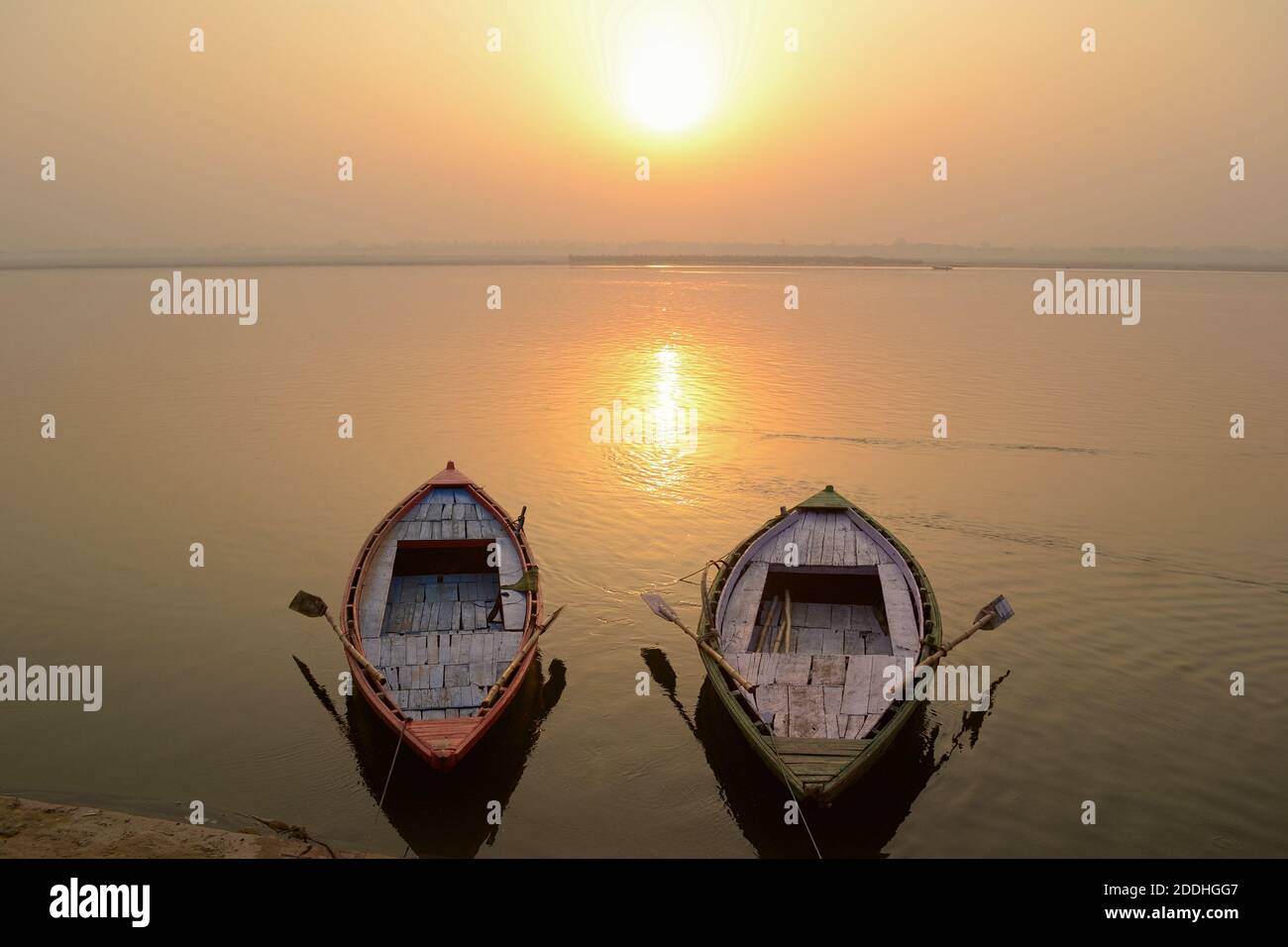 Due barche vuote sul fiume Gange nei pressi di ghats al tramonto, Varanasi, India Foto Stock