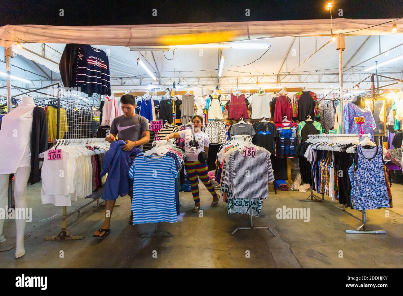 Una bancarella di vestiti che vende in un mercato notturno a Makati City, Filippine Foto Stock