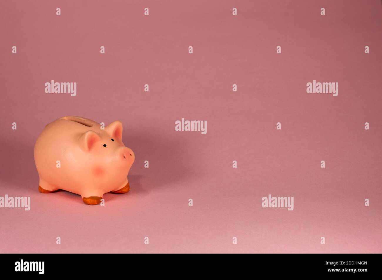 Rosa Piggy Bank lato contro sfondo rosa Foto Stock