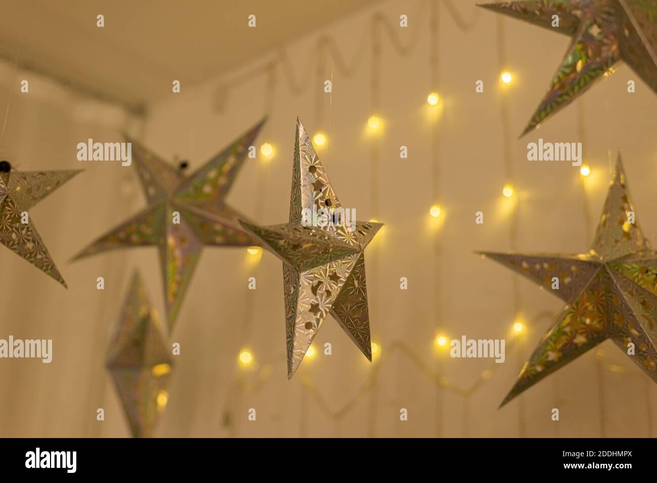 Stelle dorate illuminate e grandi palline rosse di Natale appese sul  soffitto in camera per preparare la festa di Natale Foto stock - Alamy