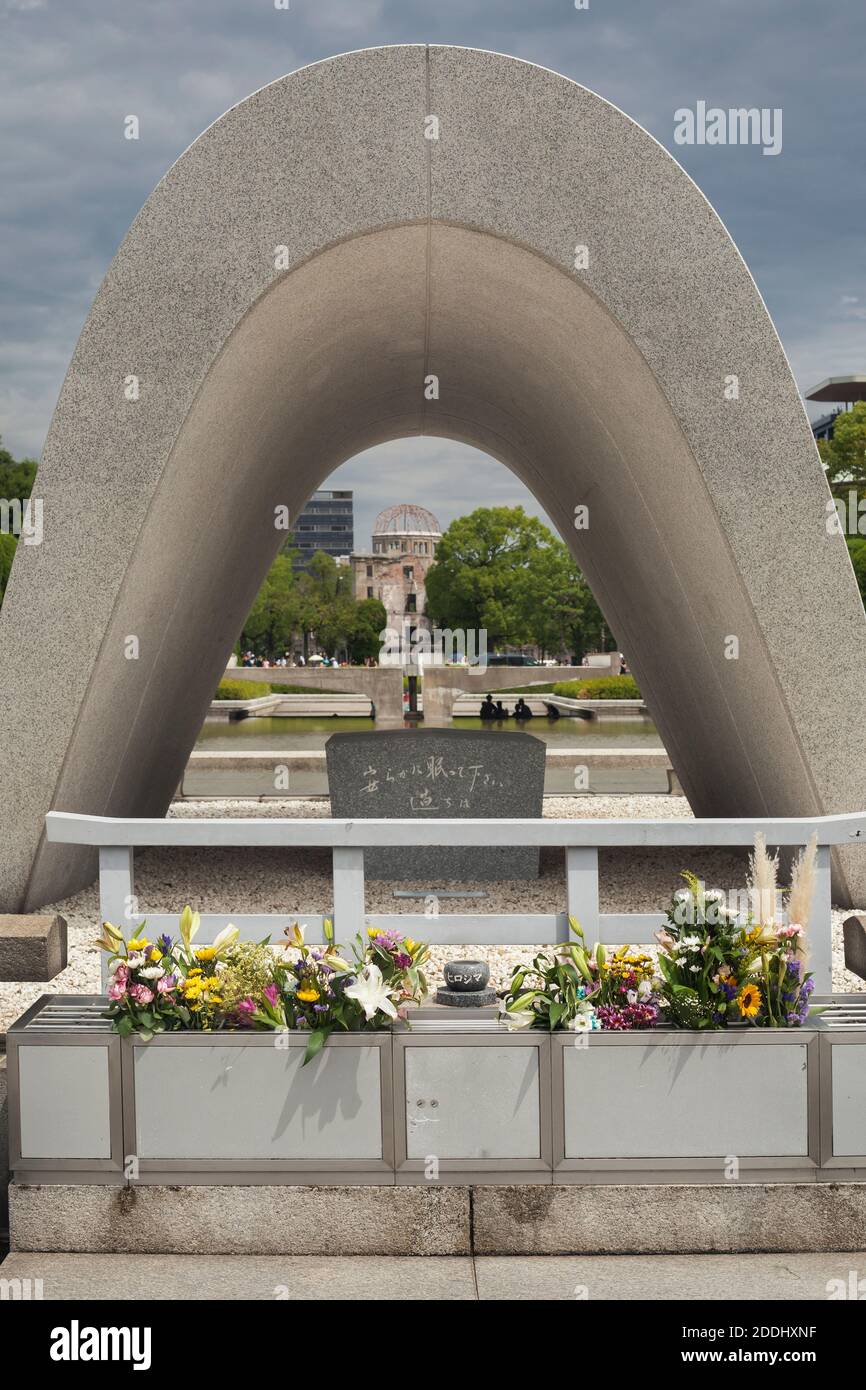 Vista ravvicinata del Cenotafh Memoriale alle vittime della seconda guerra mondiale con la cupola della bomba atomica e la fiamma della pace sullo sfondo, Hiroshima, Giappone Foto Stock