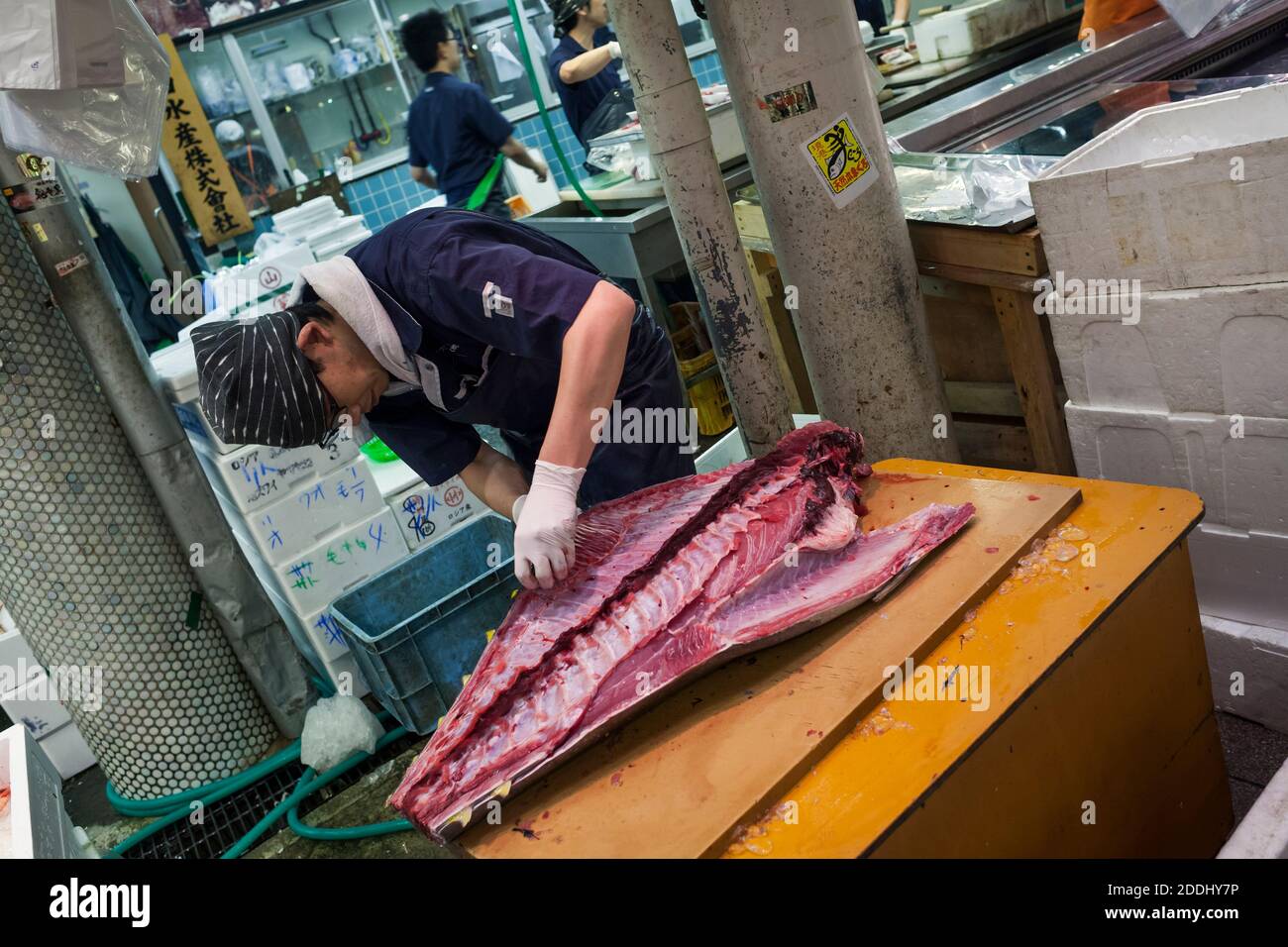 Colpo inclinato di un pescatore che pulisce un tonno in una delle bancarelle di pesce del mercato del cibo fresco di Omicho, Kanazawa, Giappone Foto Stock