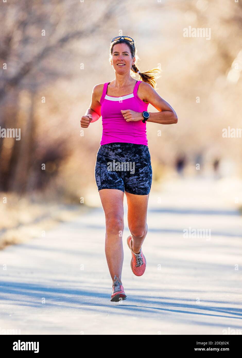 Attraente; di mezza età; fit donna che corre su sentiero lastricato; Salida; Colorado; USA Foto Stock