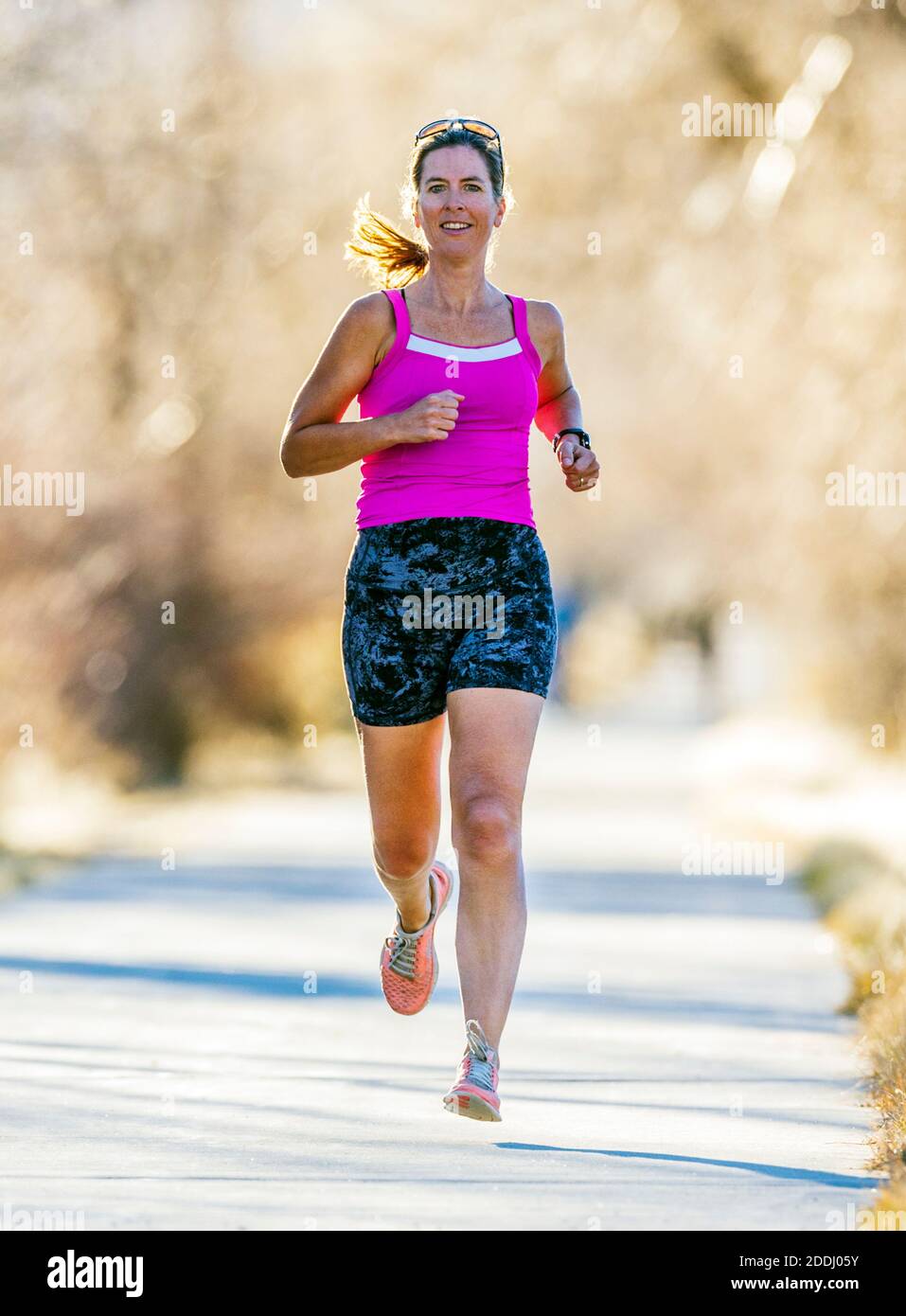 Attraente; di mezza età; fit donna che corre su sentiero lastricato; Salida; Colorado; USA Foto Stock