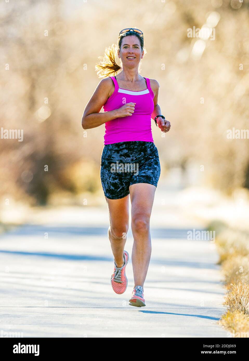 Attraente; di mezza età; fit donna che corre su sentiero lastricato; Salida; Colorado; USA Foto Stock