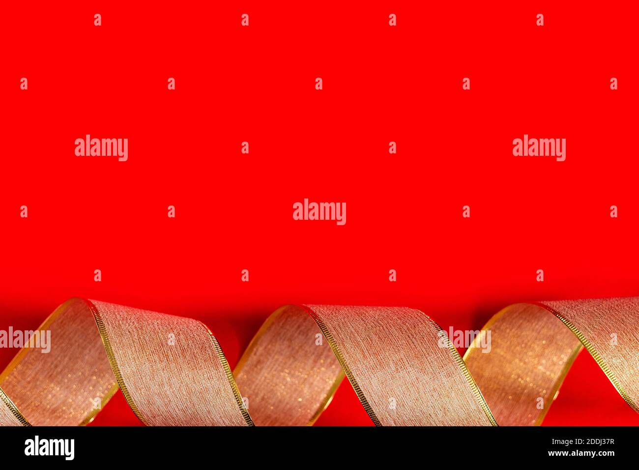 Nastro d'oro su sfondo rosso. nastro d'imballaggio d'oro ricci su sfondo rosso, sfondo nuovo anno, spazio copia, posto per testo, banner, vacanza Foto Stock