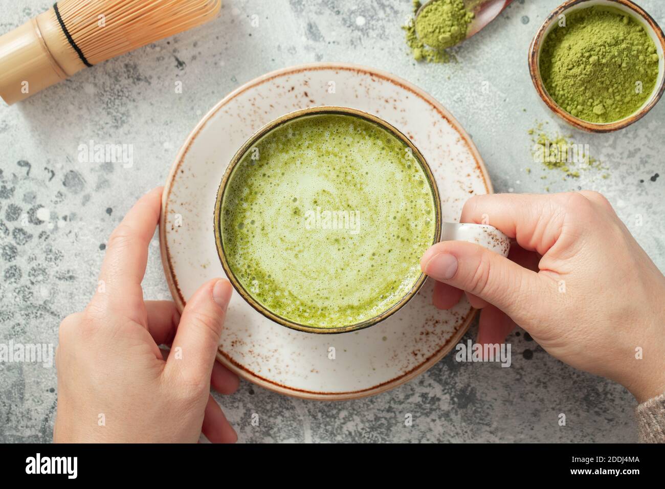 Tazza di tè verde Matcha nelle mani della donna. Vista dall'alto. Disposizione piatta Foto Stock