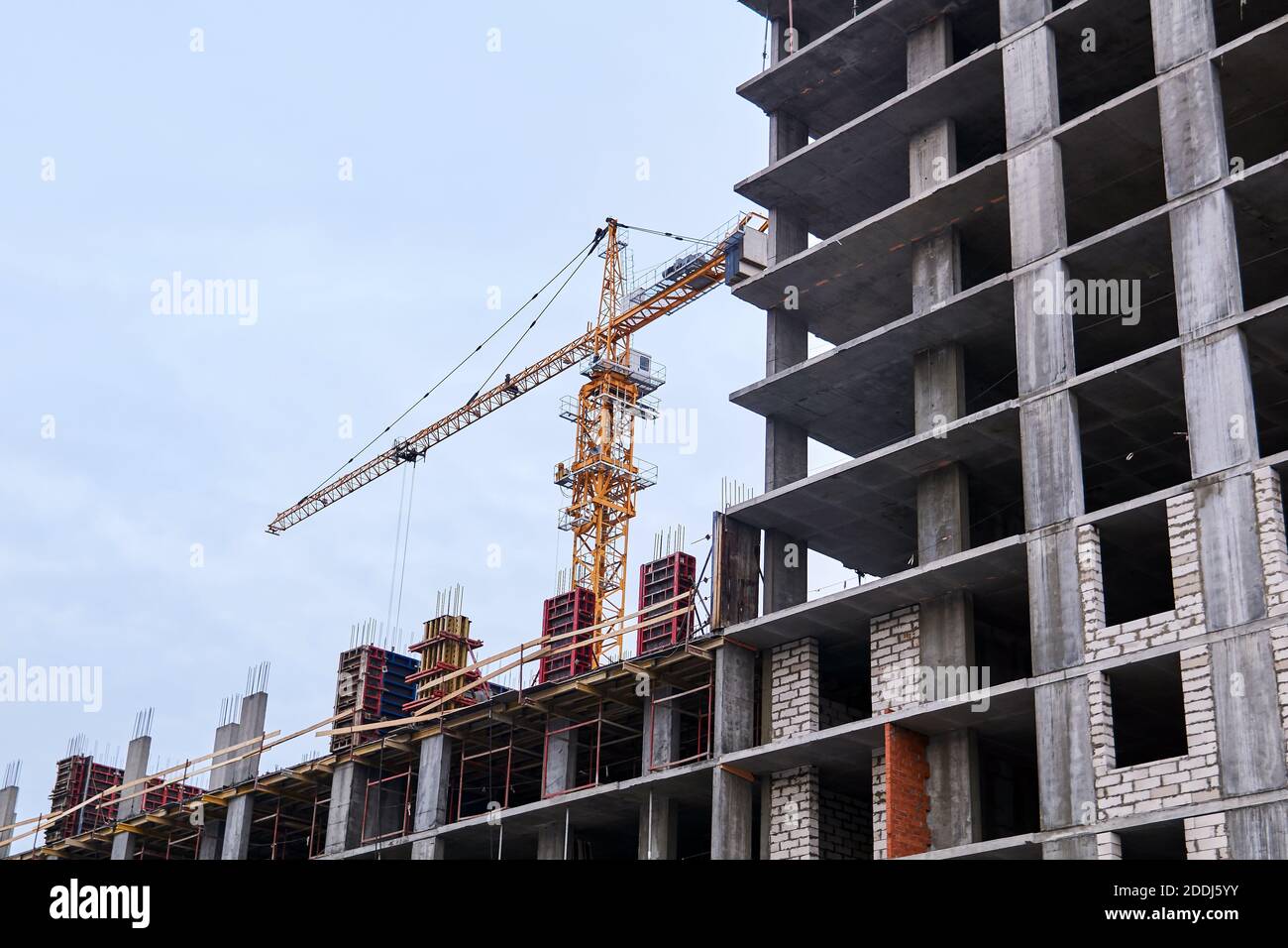 alto edificio in costruzione e gru contro il cielo Foto Stock