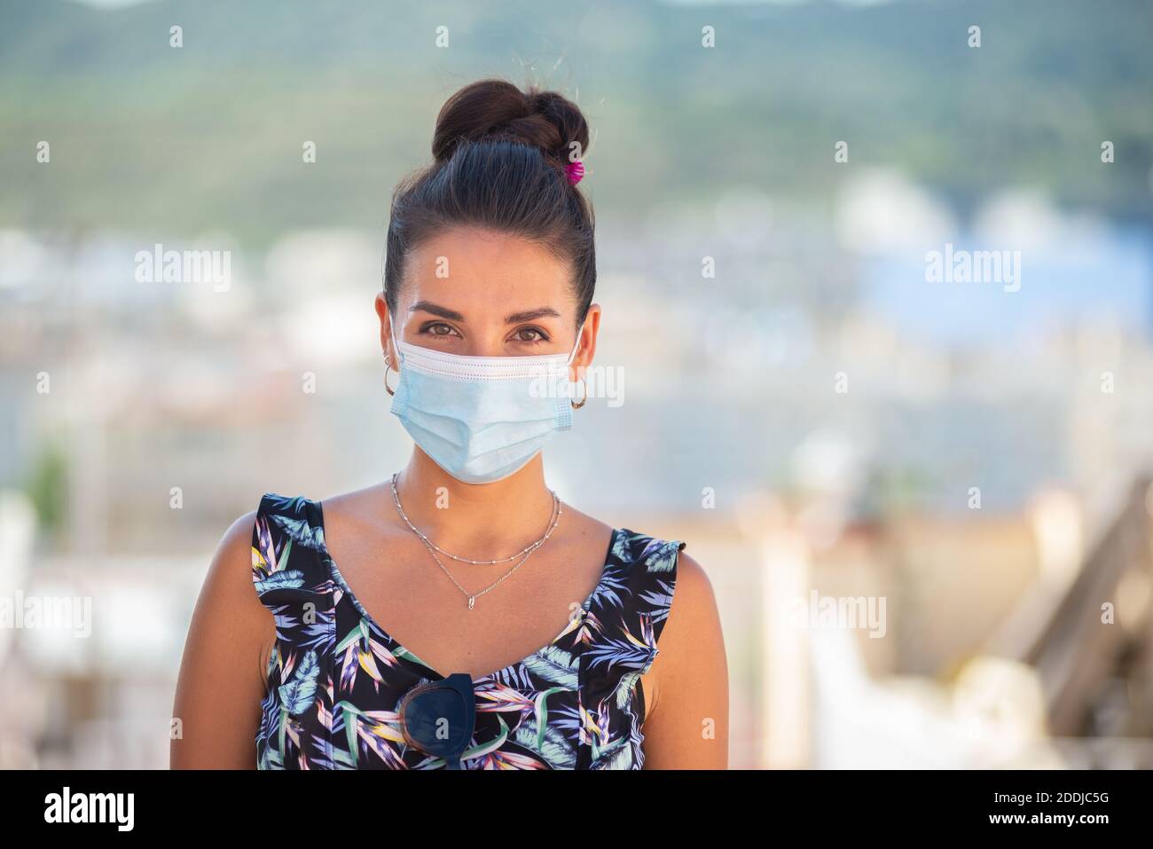 Giovane donna che indossa una maschera di protezione Foto Stock