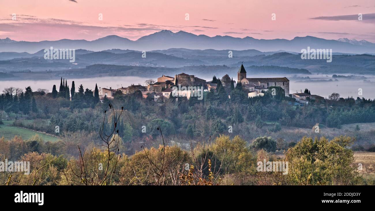 Cailhau, Aude France. 11/25/20 Alba vista sul villaggio guardando verso la catena montuosa dei Pirenei francesi. Nebbie del mattino presto. Chiesa e campana Foto Stock